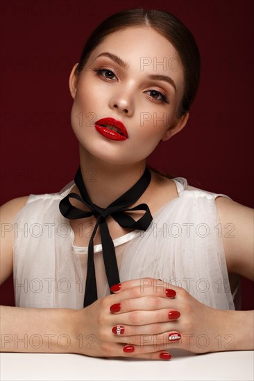 Beautiful girl in white dress with classic make-up and red manicure. Beauty face. Photo taken in the studio