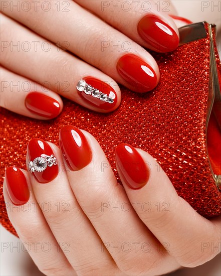 Bright festive red manicure on female hands. Nails design