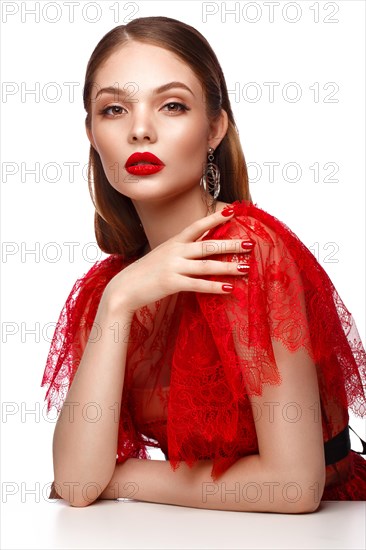 Beautiful girl in red dress with classic make-up and red manicure. Beauty face. Photo taken in the studio