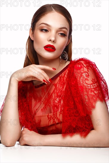 Beautiful girl in red dress with classic make-up and red manicure. Beauty face. Photo taken in the studio