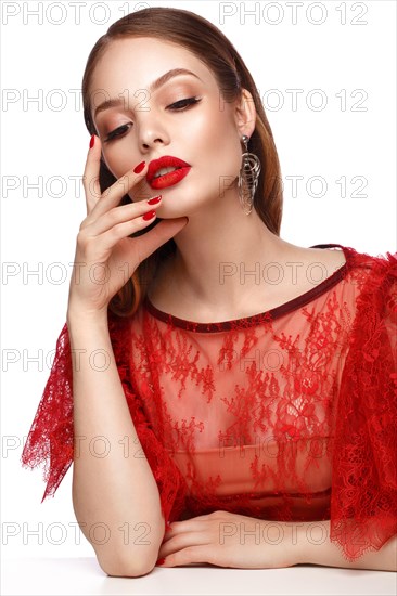 Beautiful girl in red dress with classic make-up and red manicure. Beauty face. Photo taken in the studio