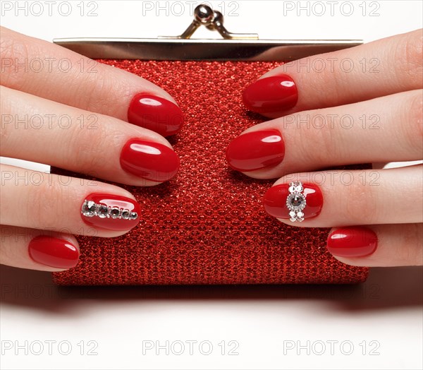 Bright festive red manicure on female hands. Nails design