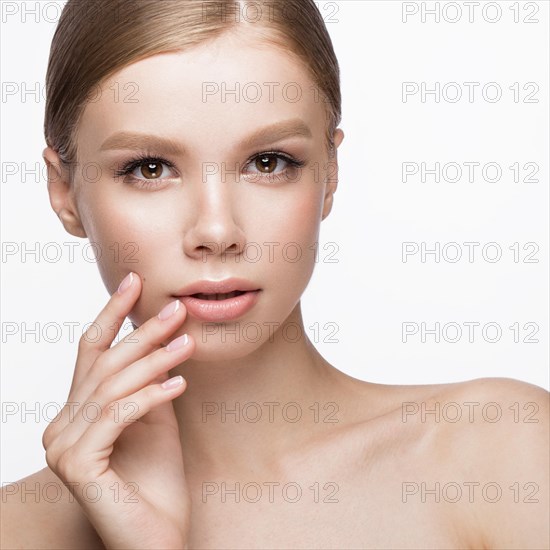 Beautiful young girl with a light natural make-up and French manicure. Beauty face. Picture taken in the studio on a white background