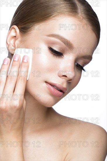 Beautiful young girl with wipes for removing makeup and French manicure. Beauty face. Picture taken in the studio on a white background