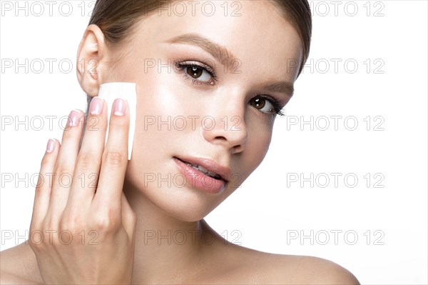 Beautiful young girl with wipes for removing makeup and French manicure. Beauty face. Picture taken in the studio on a white background