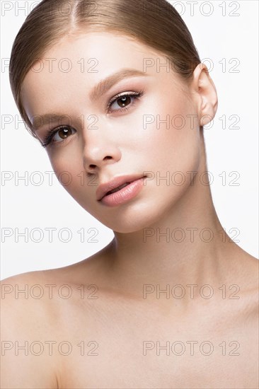 Beautiful young girl with a light natural make-up. Beauty face. Picture taken in the studio on a white background