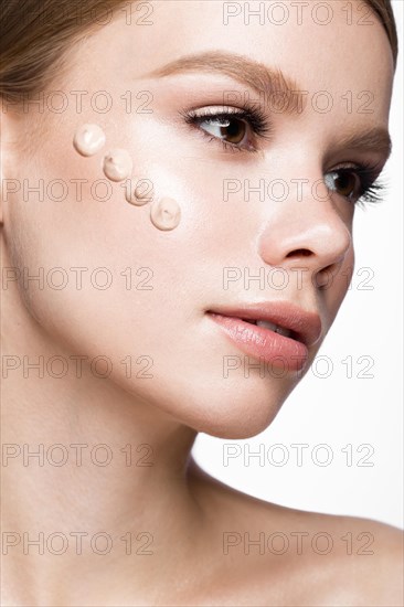 Beautiful young girl with tone cream on her skin. Beauty face. Picture taken in the studio on a white background