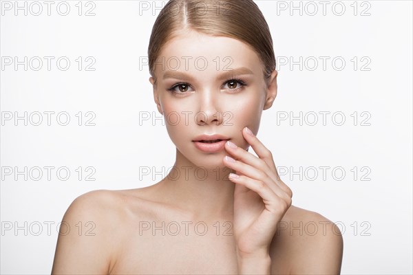 Beautiful young girl with a light natural make-up and French manicure. Beauty face. Picture taken in the studio on a white background