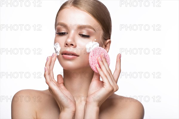 Beautiful young girl with sponge and foam cleanser and French manicure. Beauty face. Picture taken in the studio on a white background