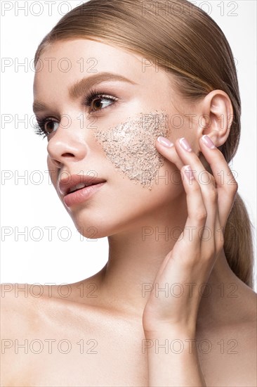Beautiful young girl with scrub on the skin and French manicure. Beauty face. Picture taken in the studio on a white background
