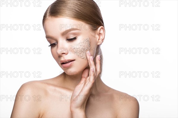 Beautiful young girl with scrub on the skin and French manicure. Beauty face. Picture taken in the studio on a white background