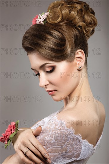 Portrait of a beautiful woman in the image of the bride with flowers in her hair. Picture taken in the studio on a black background