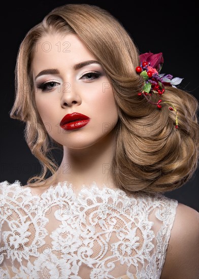 Portrait of a beautiful blond girl in image of the bride with purple flowers on her head. Beauty face. Photo shot in the Studio on a grey background