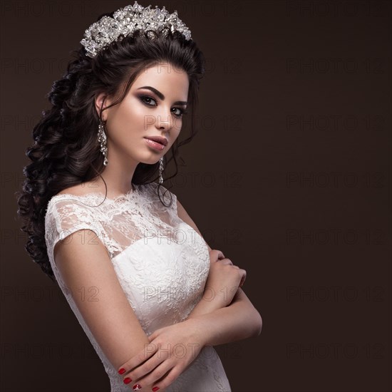 Beautiful brunette girl in the image of the Arab bride in a wedding dress and a crown on her head. Beauty face. Picture taken in the studio