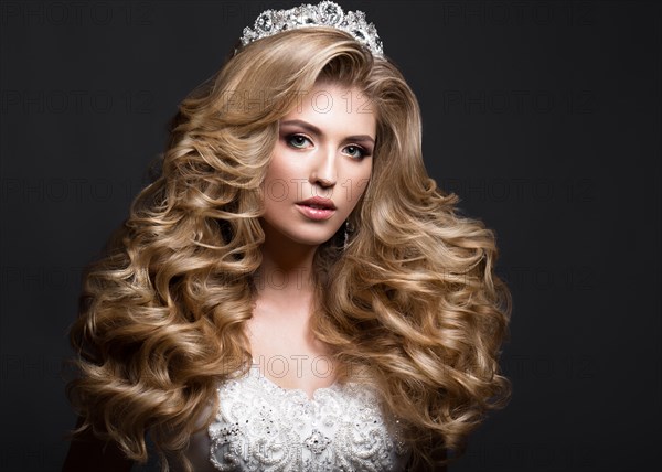 Beautiful blonde bride in wedding image with curls and crown. Beauty face. Picture taken in the studio