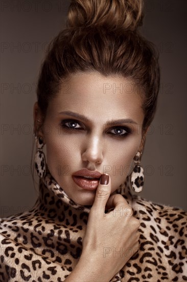 Beautiful sexy woman in a leopard coat and earrings