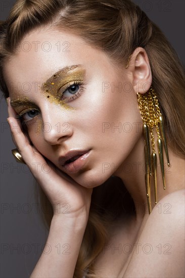 Beautiful girl in Underwear with creative gold makeup and hair. The beauty of the face. Photos shot in the studio