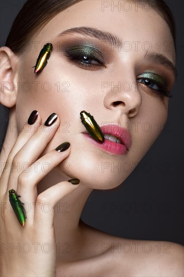 Portrait of beautiful girl with colorful make-up and cockroaches. Beauty face. Photo taken in the studio