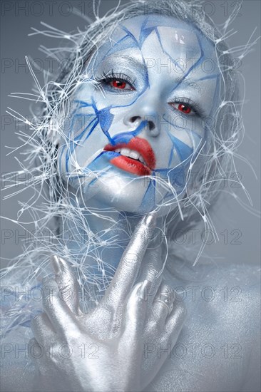 Beautiful girl in an unusual winter look with red lips. Creative make up. Art look. Photo taken in studio