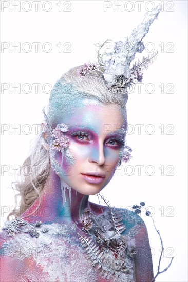 Beautiful girl in the image of a snowy unicorn creature. Creative make up. Art looks. Photo taken in the studio