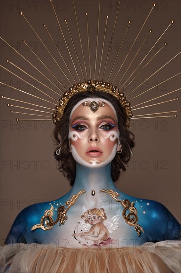 Portrait of a girl with gold and blue creative art make-up. Photo taken in the studio. Renaissance