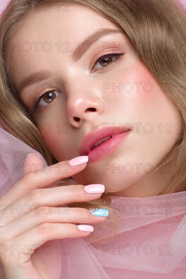 Beautiful girl with light make-up and gentle manicure in pink clothes. Beauty face. Design nails. Photo taken in studio on pink background