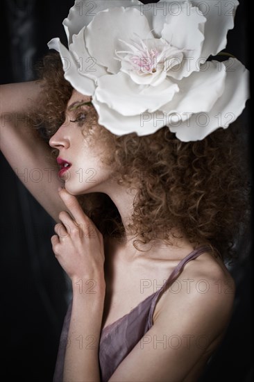 Beautiful girl with curly hair in lingerie with large flower. The beauty of the face. Photos shot in studio