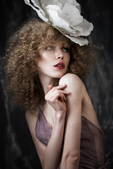 Beautiful girl with curly hair in lingerie with large flower. The beauty of the face. Photos shot in studio
