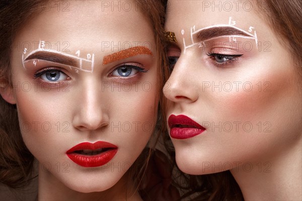 Two girls are twin sisters with an unusual eyebrow makeup. Beauty face. Photo taken in the studio