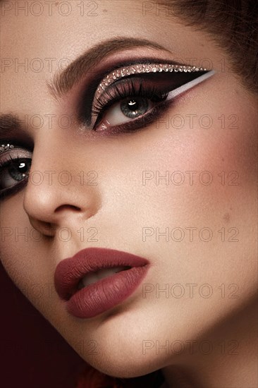 Portrait of a beautiful woman in a disco style image with creative makeup and hairstyle