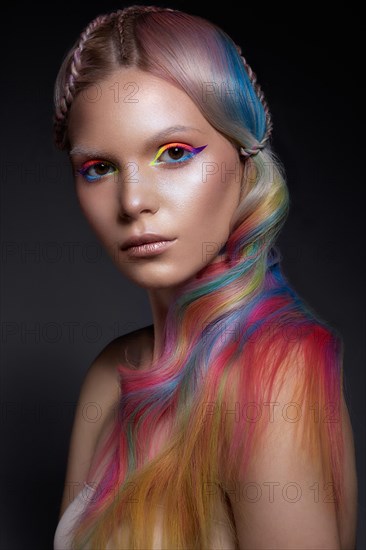 Beautiful girl with multi-colored hair and creative make-up and hairstyle. Beauty face. Photo taken in the studio