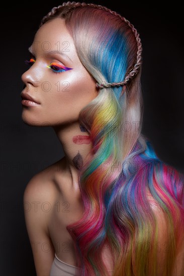 Beautiful girl with multi-colored hair and creative make-up and hairstyle. Beauty face. Photo taken in the studio