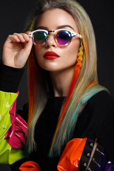 Beautiful girl with multi-colored hair and creative make-up and hairstyle. Beauty face. Photo taken in the studio