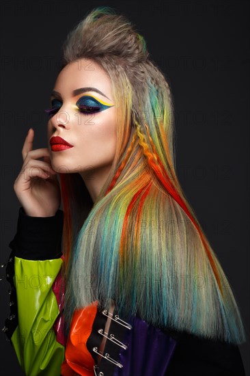 Beautiful girl with multi-colored hair and creative make-up and hairstyle. Beauty face. Photo taken in the studio