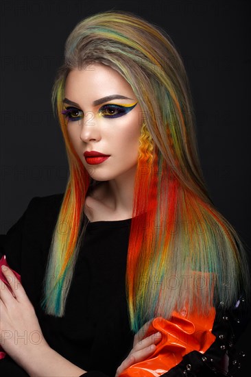 Beautiful girl with multi-colored hair and creative make-up and hairstyle. Beauty face. Photo taken in the studio