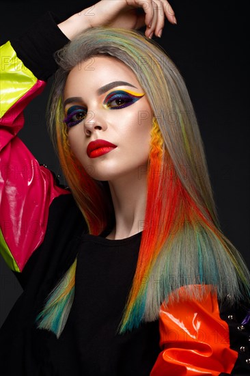 Beautiful girl with multi-colored hair and creative make-up and hairstyle. Beauty face. Photo taken in the studio