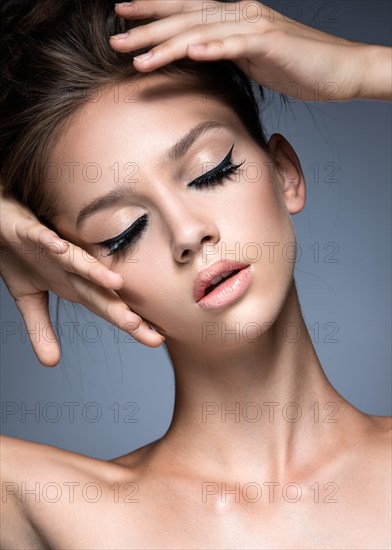 Beautiful girl with long eyelashes and perfect skin. Picture taken in the studio on a gray background. Beauty face