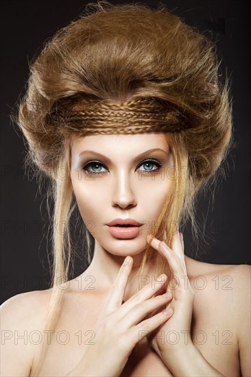 Beautiful red-haired girl with perfect skin and an unusual hairstyle. Picture taken in the studio on a black background