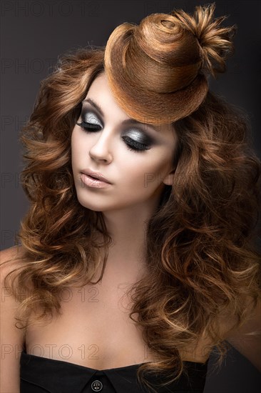 Beautiful woman with evening make-up and hairstyle as a cap of hair. Beauty face. Picture taken in the studio on a gray background