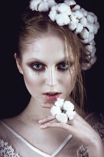 Art fashion girl with creative makeup and cotton in her hair. Beauty face. Picture taken in the studio