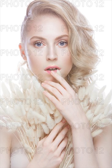 Beautiful girl with a gentle make-up and hairstyle with ears of corn in her hands. Beauty face. Picture taken in the studio