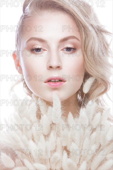 Beautiful girl with a gentle make-up and hairstyle with ears of corn in her hands. Beauty face. Picture taken in the studio