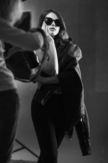 Beautiful girl posing on a photo shoot in the studio. Black and white image