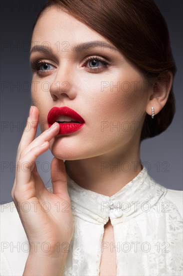 Beautiful girl with red lips in white clothes in the form of retro. Beauty face. Picture taken in the studio