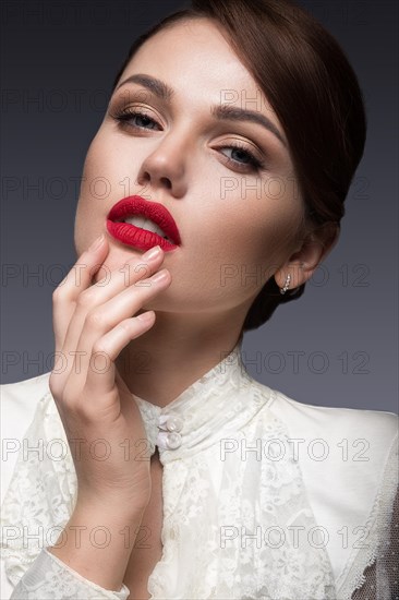 Beautiful girl with red lips in white clothes in the form of retro. Beauty face. Picture taken in the studio