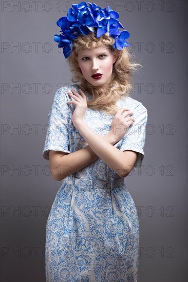 Girl with flowers on her head in a dress in the Russian style. Picture taken in the studio