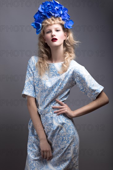 Girl with flowers on her head in a dress in the Russian style. Picture taken in the studio