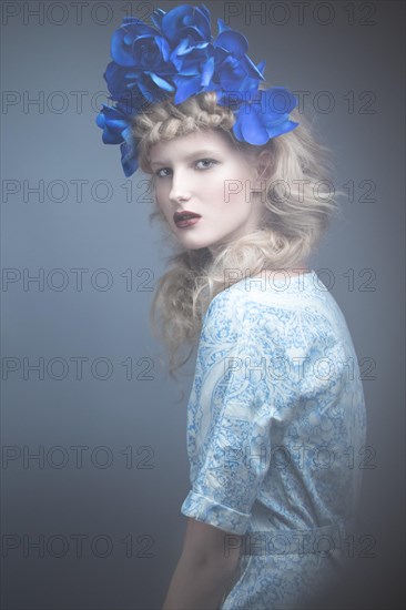 Girl with flowers on her head in a dress in the Russian style. Picture taken in the studio