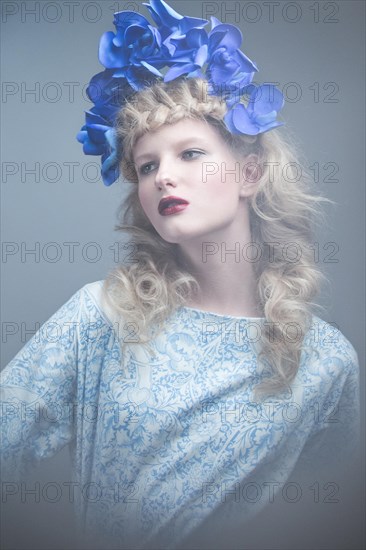 Girl with flowers on her head in a dress in the Russian style. Picture taken in the studio