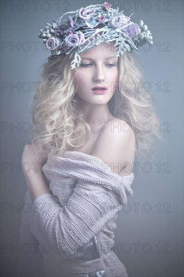 Girl with flowers on her head in a dress in the Russian style. Picture taken in the studio